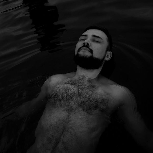 A person meditating peacefully in a calm, natural setting.